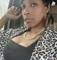 a woman in a leopard print jacket sitting in a car